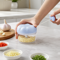 Hachoir Manuel Express bleu en action — ail haché dans le bol transparent | Cuisine Futée